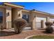 Front exterior shows desert landscaping, wrought iron fencing and two car garage at 240 Vineyard Ln, Mesquite, NV 89027