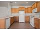 Bright kitchen with oak cabinets, tile flooring, and white appliances at 240 Vineyard Ln, Mesquite, NV 89027