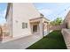 Charming backyard features a covered patio, artificial grass, and decorative string lights for a cozy outdoor space at 2482 Denholme St, Henderson, NV 89044