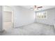 Spacious bedroom with plush gray carpet, neutral walls, ceiling fan and window at 2482 Denholme St, Henderson, NV 89044