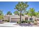 Single-story home with desert landscaping, tan stucco, and a two-car garage at 2509 Banora Point Dr, Las Vegas, NV 89134