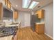Galley style kitchen with wood cabinets, stainless steel appliances, and wood floors at 2509 Banora Point Dr, Las Vegas, NV 89134