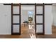 Home office with wooden sliding doors, hardwood floors and a sunlit window at 2548 Faiss Dr, Las Vegas, NV 89134