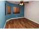 Bedroom with wooden floors, blue accent wall, and two windows for natural light at 2787 Sunken Ship St, Laughlin, NV 89029