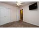 Bedroom features carpet flooring, ceiling fan, closet with white sliding doors and mounted TV at 2787 Sunken Ship St, Laughlin, NV 89029