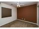 Bedroom with neutral carpet, brown accent wall, ceiling fan and window at 2787 Sunken Ship St, Laughlin, NV 89029