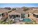 Aerial view of the backyard with a pool, covered patio, outdoor kitchen, and mountain views at 305 Via Del Duomo, Henderson, NV 89011