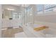 Bright bathroom features a soaking tub, a glass enclosed shower and dual sinks with a large mirror at 305 Via Del Duomo, Henderson, NV 89011
