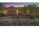 Charming single-story home featuring a desert landscape, and a two car garage at sunset at 305 Via Del Duomo, Henderson, NV 89011