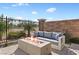 Outdoor seating area featuring an outdoor sofa and a fire pit with landscaping and fencing at 305 Via Del Duomo, Henderson, NV 89011