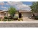 Charming single story stucco home with desert landscaping, an arched entryway and a two-car garage at 3084 Porte La Paz Ave, Henderson, NV 89044