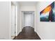 Hallway featuring hardwood floors, white walls, white doors and an eye-catching colorful art piece at 3084 Porte La Paz Ave, Henderson, NV 89044