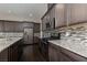 Kitchen with stainless appliances, granite countertops, tile backsplash and dark wood cabinets and floors at 3084 Porte La Paz Ave, Henderson, NV 89044