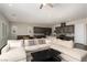 Open concept kitchen and living space with an oversized couch, tile backsplash and dark wood floors at 3084 Porte La Paz Ave, Henderson, NV 89044