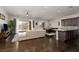Open concept living space with a large sectional couch, wood floors, and stainless kitchen appliances at 3084 Porte La Paz Ave, Henderson, NV 89044