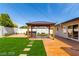 Inviting backyard featuring a pergola, artificial grass, hot tub, and stepping stones at 3308 Navajo Way, Las Vegas, NV 89108