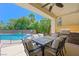 Covered patio area featuring outdoor dining, barbecue, and a view of the backyard and pool area at 335 Pleasant Summit Dr, Henderson, NV 89012