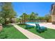 Backyard oasis featuring a well-manicured lawn, a custom pool, lounge chairs, and lush landscaping at 335 Pleasant Summit Dr, Henderson, NV 89012