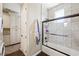 Bathroom featuring wood-look floors, a bathtub with glass doors, and convenient access to a washer and dryer at 335 Pleasant Summit Dr, Henderson, NV 89012
