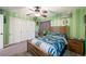 Green striped bedroom featuring a ceiling fan, bed with blue bedspread, and desk at 335 Pleasant Summit Dr, Henderson, NV 89012