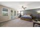Large primary bedroom with French doors, ceiling fan, and a gray accent wall at 335 Pleasant Summit Dr, Henderson, NV 89012