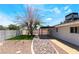 Backyard featuring mature trees, a covered patio, artificial lawn, and low maintenance rock landscaping at 3572 Tempe St, Las Vegas, NV 89103