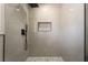 Close up of modern shower featuring light-colored tile, rainfall shower head and black trim at 3572 Tempe St, Las Vegas, NV 89103