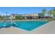 Community pool with a chair lift for accessibility and a clear view of nearby buildings and palm trees at 4130 E Brusca Way, Pahrump, NV 89061