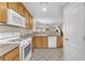 Functional kitchen with wooden cabinets, white appliances, and an open layout into the adjacent living space at 4252 Olympic Point Dr, Las Vegas, NV 89129