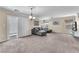 Open living room featuring plush carpeting, a comfortable sofa, and a sliding glass door to the backyard at 4252 Olympic Point Dr, Las Vegas, NV 89129