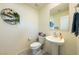 Charming half bathroom featuring pedestal sink and decorative wall art at 440 Blue Lark Dr, Henderson, NV 89011