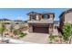 Two-story home with a two-car garage, paver driveway and desert landscaping at 440 Blue Lark Dr, Henderson, NV 89011