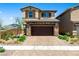 Charming two-story home with a stone-accented facade, a brick driveway, and a well-maintained front yard at 440 Blue Lark Dr, Henderson, NV 89011