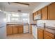 Functional kitchen with white appliances, wood cabinets, and laminate countertops convenient for daily cooking at 45 Maleena Mesa St # 1321, Henderson, NV 89074