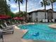 Community pool featuring palm trees and lounge chairs with a blue inflatable in the water at 45 Maleena Mesa St # 1321, Henderson, NV 89074