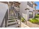 Stairwell for an upstairs unit features a textured walkway and lush shrubbery on either side, creating an inviting entry at 45 Maleena Mesa St # 1321, Henderson, NV 89074