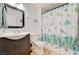 Bright bathroom with dark vanity, toilet, and tub-shower combo with cheerful shower curtain at 5000 Red Rock St # 248, Las Vegas, NV 89118