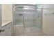 Bathroom with a shower behind a sliding glass door and a vanity with white cabinets at 5398 Robinera Ct, Las Vegas, NV 89166