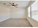 Spacious bedroom features plush carpeting, a ceiling fan, and bright natural light from double windows at 5398 Robinera Ct, Las Vegas, NV 89166