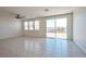 Bright living room with tile flooring, neutral walls, ceiling fan, and glass sliding door at 5398 Robinera Ct, Las Vegas, NV 89166