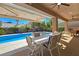 Covered patio area by pool featuring outdoor dining and lounge seating at 5416 Alabaster Ct, Las Vegas, NV 89149
