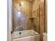 Modern tub and shower with glass enclosure and marble tile walls at 5416 Alabaster Ct, Las Vegas, NV 89149