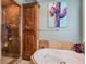 This primary bathroom features a glass shower, soaking tub, cabinet, and cactus artwork at 5416 Alabaster Ct, Las Vegas, NV 89149