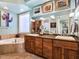 Bathroom features double sinks, a soaking tub, stone accents, and decorative wall art at 5416 Alabaster Ct, Las Vegas, NV 89149