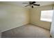 Carpeted bedroom featuring natural light from the window and a ceiling fan at 5808 Amber Station Ave, Las Vegas, NV 89131