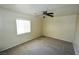A carpeted bedroom featuring a ceiling fan and natural light from the window at 5808 Amber Station Ave, Las Vegas, NV 89131