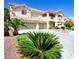 Inviting two-story home featuring a three-car garage, balcony, and beautifully landscaped front yard at 5808 Amber Station Ave, Las Vegas, NV 89131