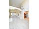 Bright open living room with wood-look tile, staircase, and views of the kitchen and entryway at 5808 Amber Station Ave, Las Vegas, NV 89131