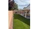 Spacious backyard featuring artificial grass, a shaded patio, and a privacy fence at 6022 Highland Gardens Dr, North Las Vegas, NV 89031