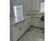 Bright kitchen with white cabinets, marble countertops, and stainless steel sink at 6022 Highland Gardens Dr, North Las Vegas, NV 89031